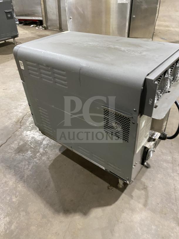 Industrial-grade equipment with visible ventilation grilles and wear marks, standing on wheels in a warehouse.