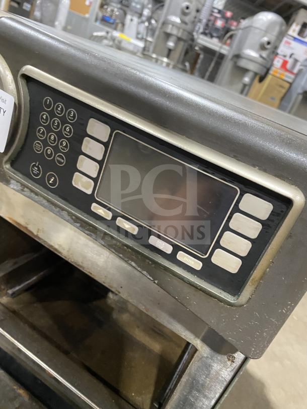Industrial oven control panel with keypad and digital display, showing signs of wear.