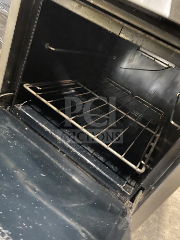 Southbend S241E commercial stainless steel range/oven combo, 4 burners, natural gas, backsplash, wired rack, on casters.