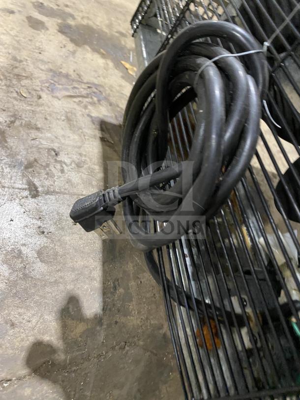 Coiled power cord on a black wired rack, part of Migali C-U60R-HC commercial refrigerator, 115V, 1 Phase.