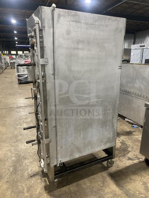 Attias commercial stainless steel gas-powered rotisserie cabinet on casters. Full-height, robust construction, industrial setting.