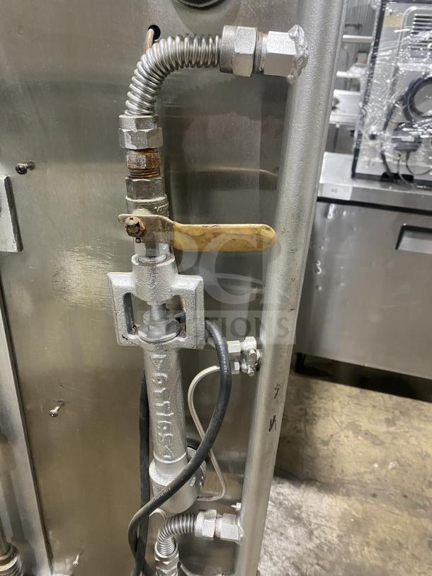 Attias stainless steel gas rotisserie cabinet, full-height, on casters. Visible gas connector and valve details.