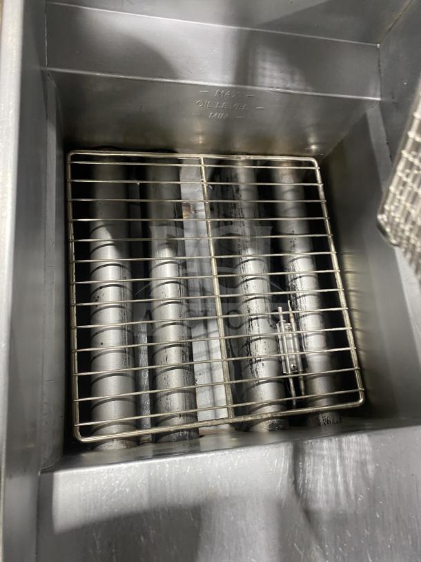 Pitco SFSG14 stainless steel gas fryer with backsplash, basket hanger, and fry basket. Visible oil level markings.