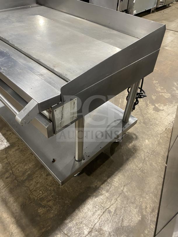 Vulcan Checkers Style commercial griddle with back/side splash, undershelf cart, stainless steel, natural gas, 120V, on casters.