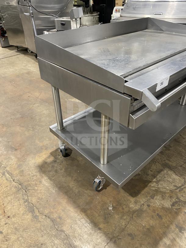 Vulcan stainless steel natural gas flat griddle with back and side splash, on casters, includes single undershelf cart.