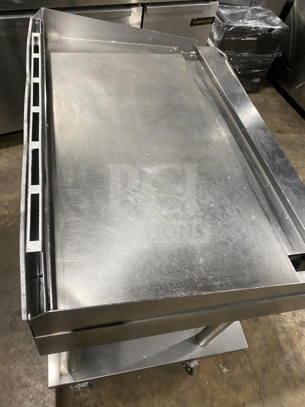 Vulcan stainless steel natural gas countertop flat griddle with back and side splash, undershelf cart on casters, 120V 1-phase.