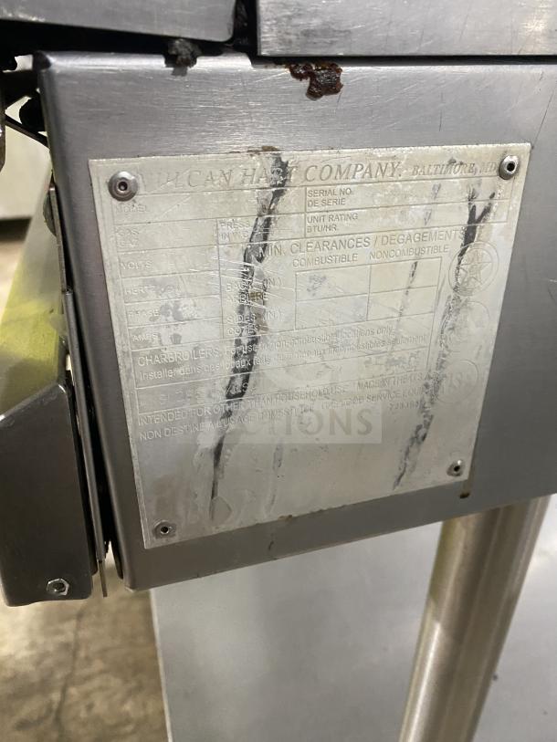 Vulcan stainless steel natural gas countertop flat griddle, back & side splash, single undershelf, on casters, visible label with specs.