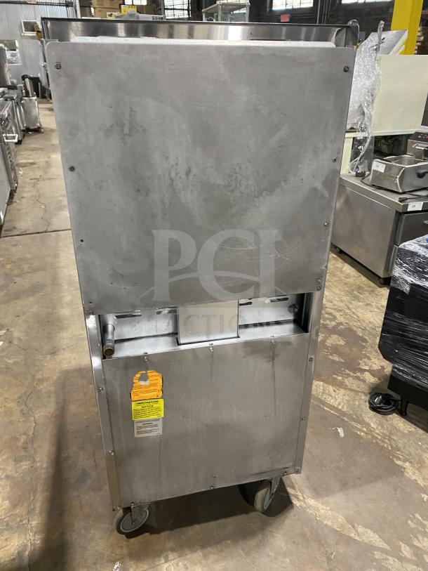 American Range commercial stainless steel 4-burner gas range/oven combo with backsplash, salamander shelf, and wired oven rack on casters.