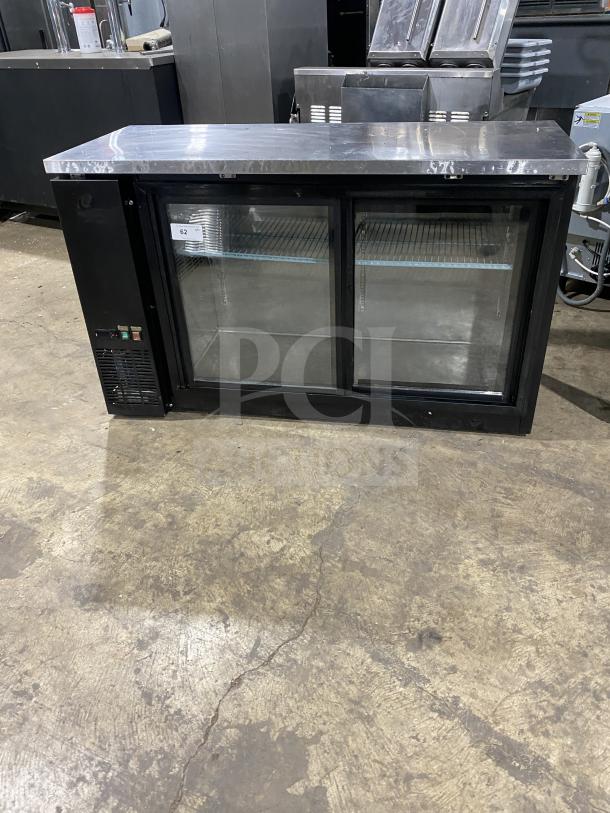 Commercial back bar black refrigerator, poly-coated wire rack, two sliding glass doors, in good condition, with label.