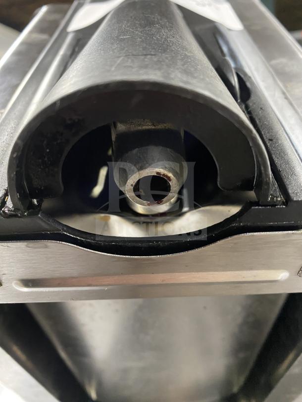 Stainless steel deli slicer in used condition, showing blade housing and cutting edge. No visible branding or labels.