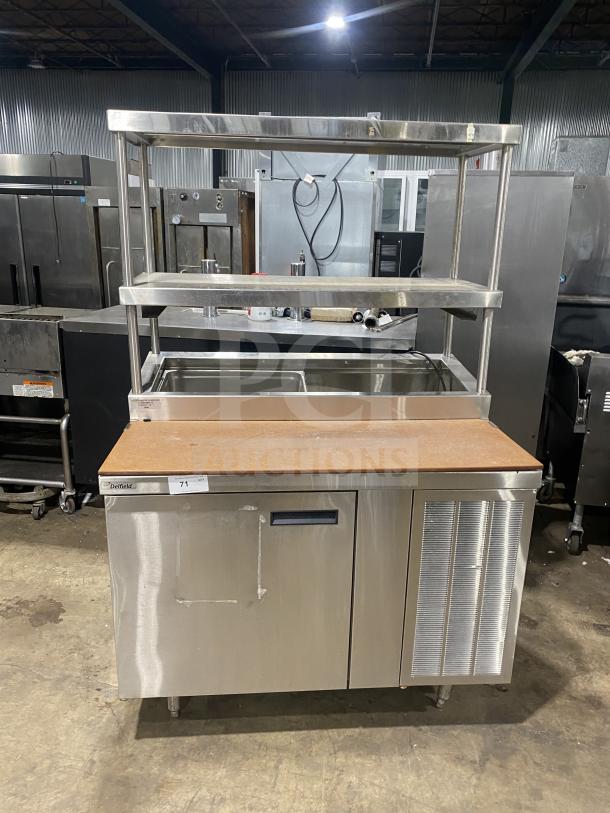 Delfield stainless steel 1-door refrigerated prep table with overhead shelves. Good condition, enclosed storage base.