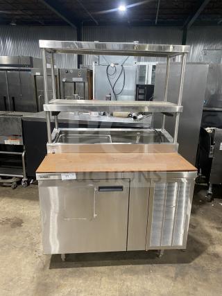 Delfield stainless steel 1-door refrigerated prep table with overhead shelves. Good condition, enclosed storage base.
