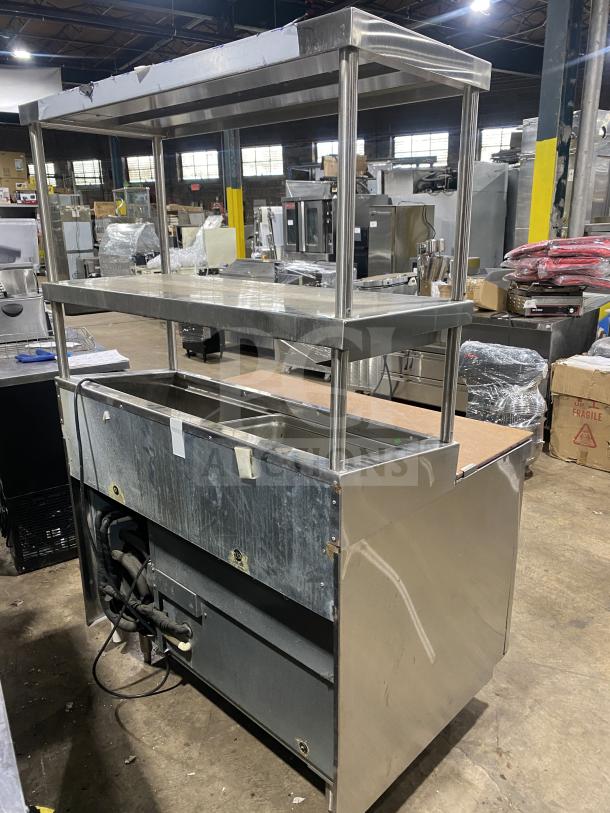 Delfield commercial stainless steel 1-door refrigerated prep table, mega top, with overhead shelf and enclosed storage.