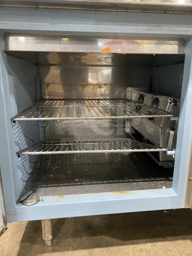 Delfield stainless steel 1-door refrigerated prep table with enclosed storage, visible shelves, and overhead shelf. Used condition.