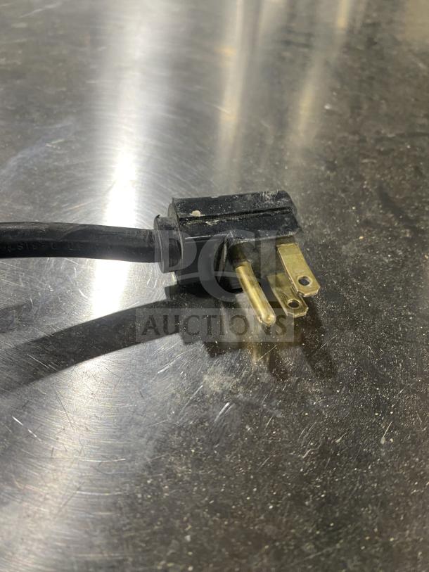 The image shows a power plug on a stainless steel surface for a Perlick BS2DP back bar refrigerator.