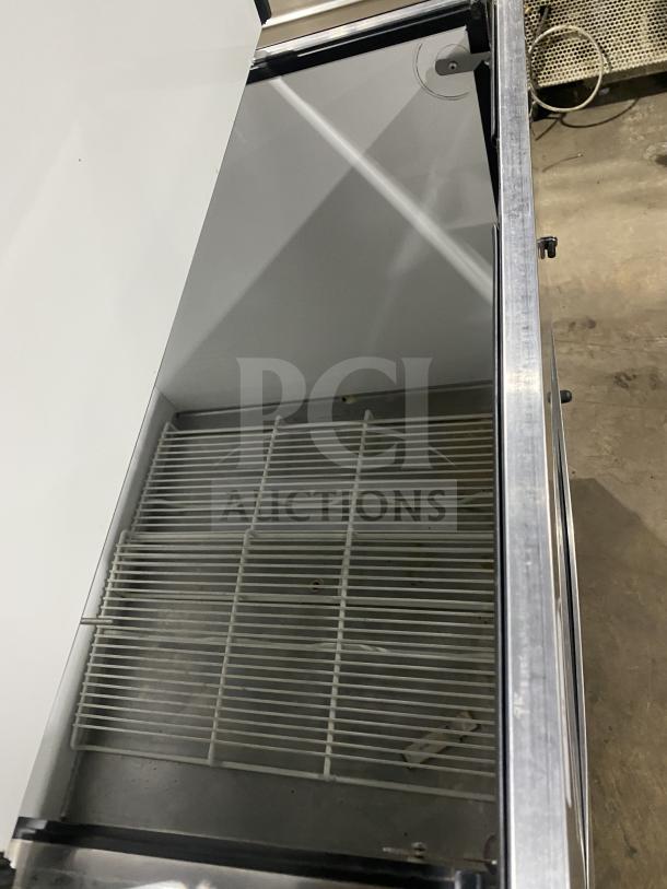 True TMCX34S stainless steel mobile milk cooler, single-sided, electric-powered, 115V 1 Phase, used, with interior shelving.