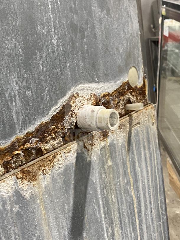 Rusted Hoshizaki KM-1301SAH3 ice machine, model SN: C00446J, 108-230V, on legs, visible corrosion near drainage area.