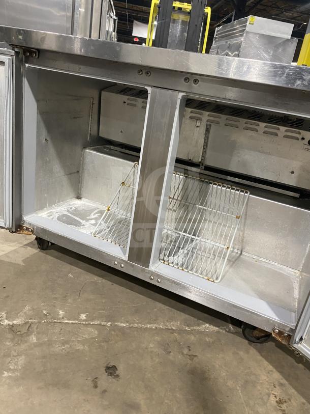 Continental stainless steel 2-door refrigerated prep table with poly-coated wired rack and casters; good condition.