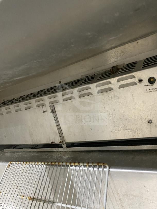 Continental stainless steel 2-door refrigerated salad/sandwich prep table with poly-coated wire rack, on casters.