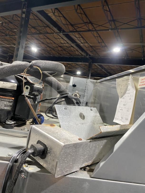 Continental 1REHD 2-door stainless steel refrigerator, good condition, features casters, rack, shelf, and visible electrical wiring.