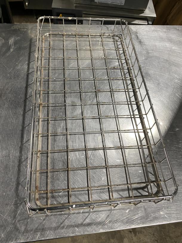 Commercial stainless steel wire rack for bagel wraps, rectangular, grid design, minor wear visible, durable construction.