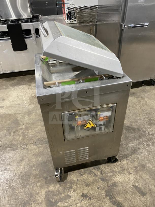 Stainless steel Multivac chamber vacuum packing machine with clear lid and visible control panel on wheels, in used condition.
