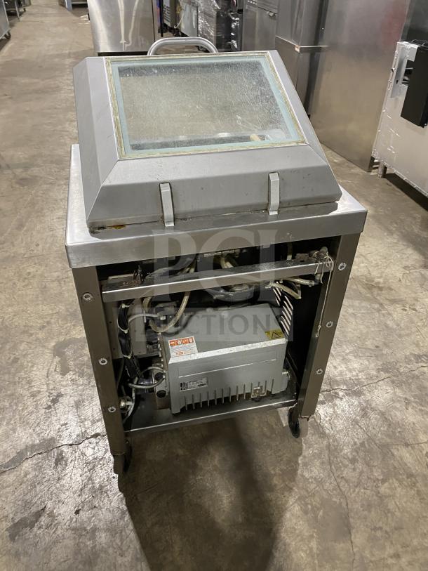 Multivac stainless steel chamber vacuum packing machine, used condition, visible internal components, industrial setting.