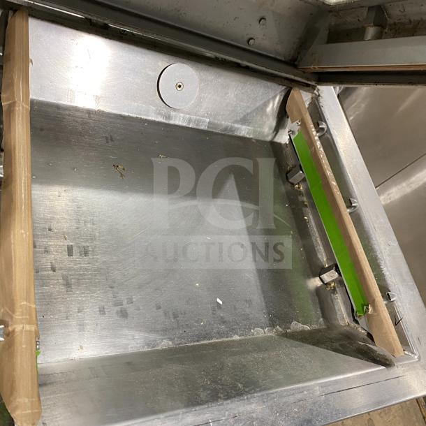 Multivac stainless steel chamber vacuum packing machine, interior view, showing metal chamber with visible wear and residue.