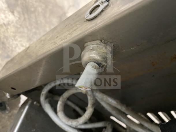 Multivac stainless steel chamber vacuum packing machine showing metal connections and wiring; noticeable wear and patina.