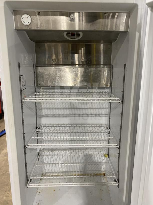 Arctic Air F22CW7 stainless steel reach-in freezer, white exterior, four wire racks, on casters. Model: F22CW7 SN: WB91910324.