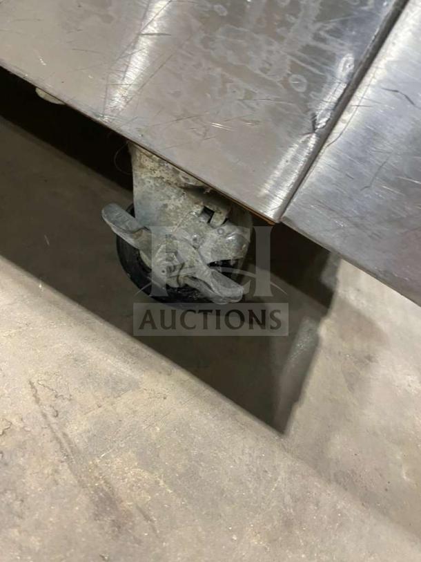 Garland stainless steel gas-powered double stacked convection oven on caster. Visible wear on surface, wired rack included.