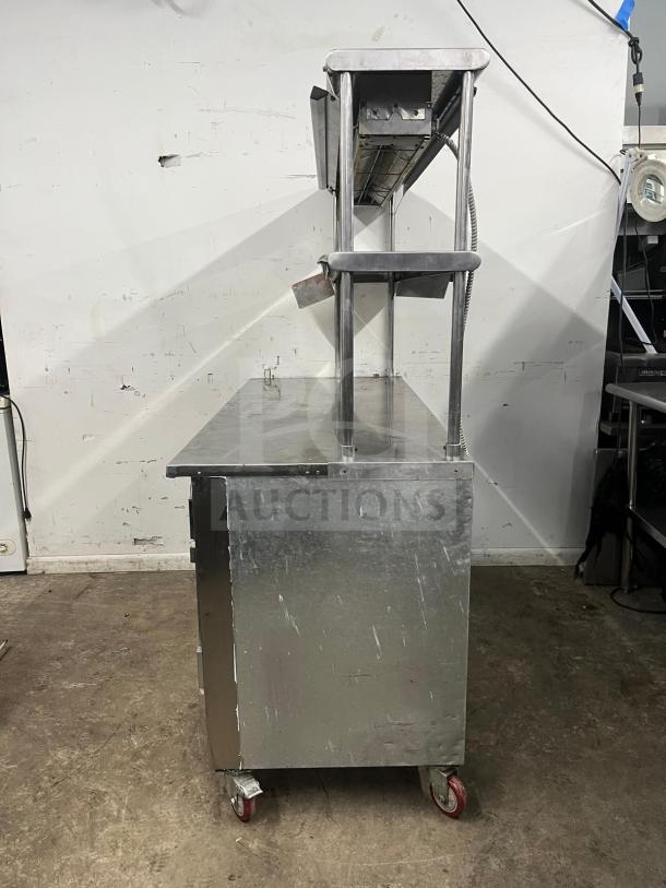 Leader LB48 under counter refrigerator, 48", with 2 full, 1 half door, double shelves, heat lamp, visible wear, on casters.