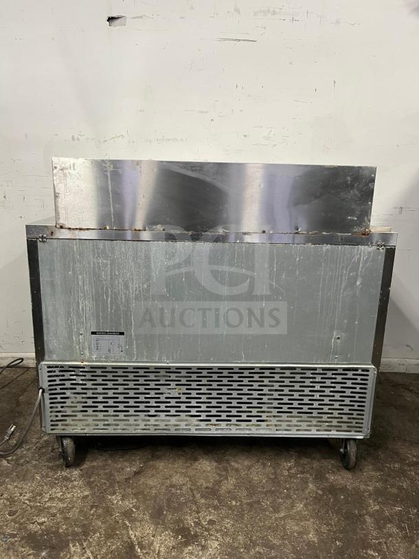 Blue Air BLMT48-HC 48" refrigerated mega top sandwich prep table with two swing doors, visible wear, on casters.