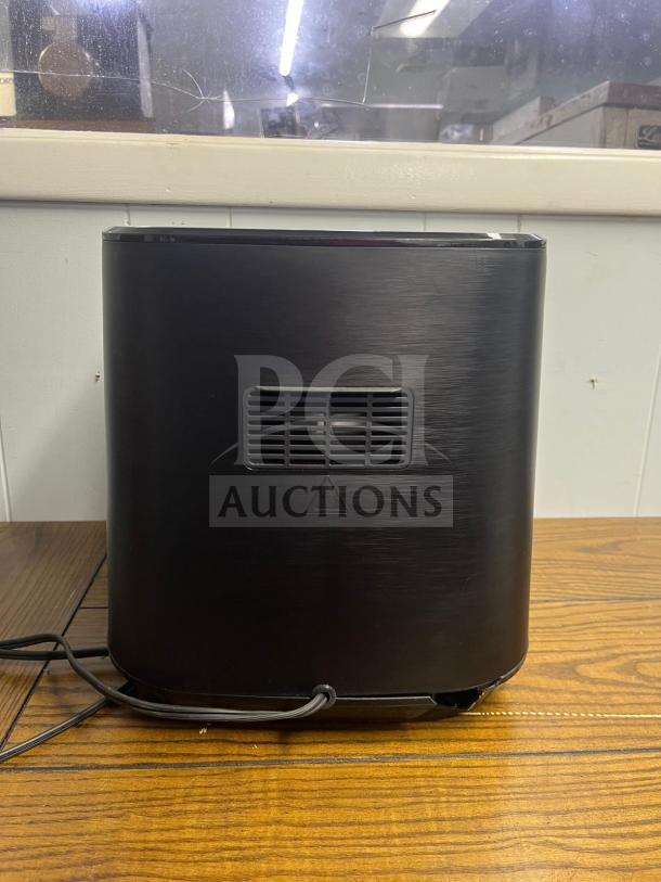 Rear view of Insignia™ 5 Qt. Digital Air Fryer, stainless steel, showing vent and power cord on a wooden surface.