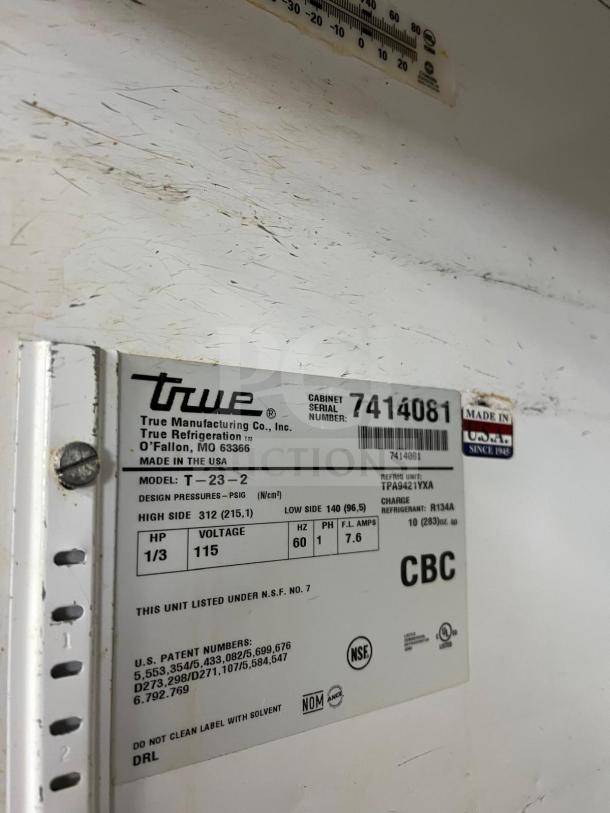 TRUE T-23-2 refrigerator label, showing make, model, voltage, serial number, and NSF certification, with visible wear marks.