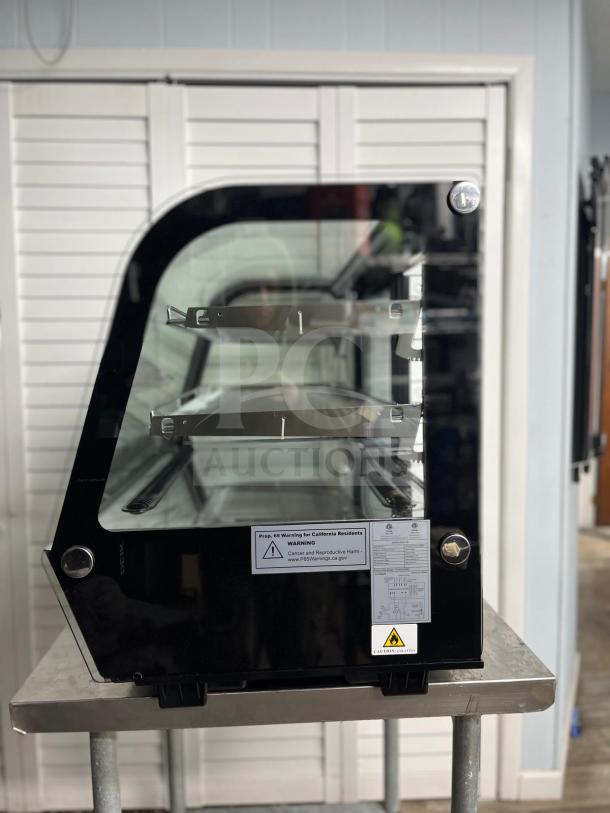 Yukon RTW-160 refrigerated display case with curved glass, excellent condition. Features interior shelves, warning labels visible.