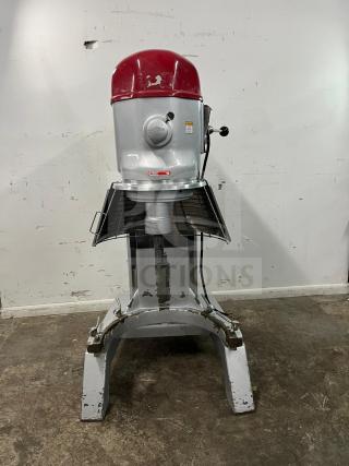 AXIS AX-M80 80QT planetary mixer. Silver body, red top, rugged base. Visible wear, model tag intact. Perfect for large-scale mixing.