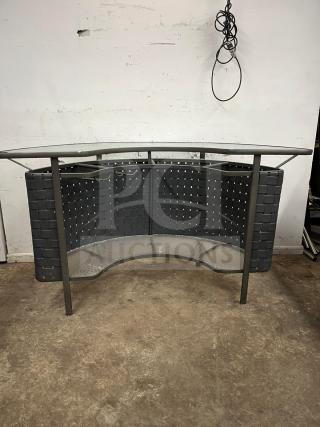 Curved outdoor bar with woven design, metal frame, and glass shelf. Good condition suitable for patio or garden use.