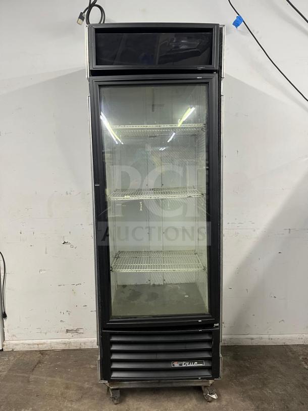 TRUE GDM-19T-LD 27" black refrigerated glass door merchandiser, with LED lighting and travel case, visible shelving.