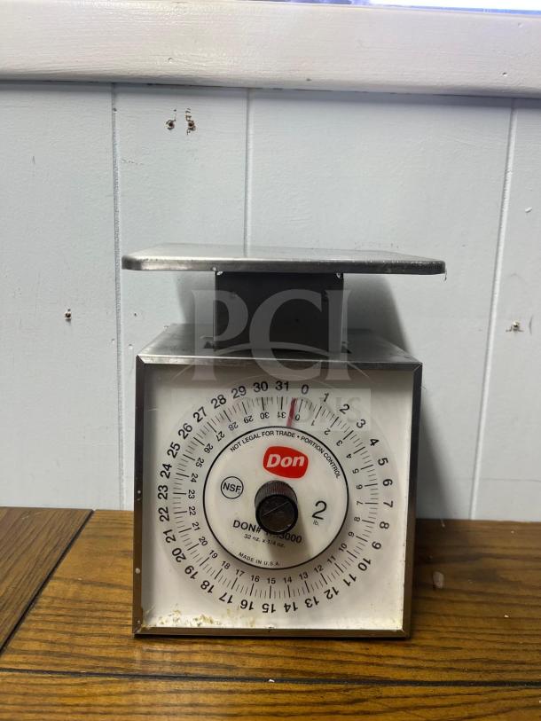 DON 5000 Mechanical Portion Control Scale, model PREMIER 5000, in used condition. Features include a stainless steel platform and NSF certification.