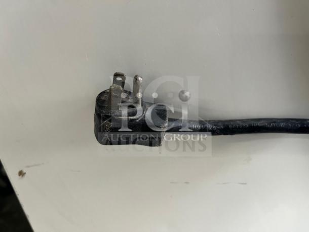 Damaged electrical plug on a display cooler, visible wear, needs repair.