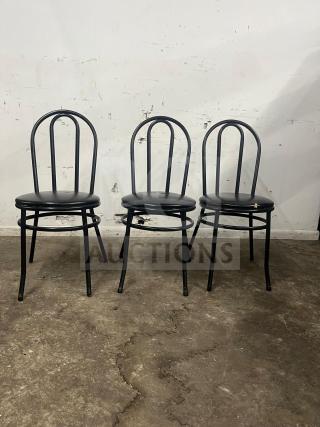 Three cafe dining chairs with black metal frames and padded vinyl seats.