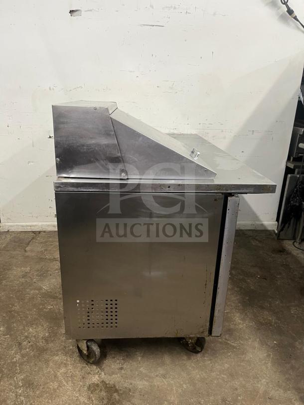 True TSSU-60-12M-B-HC refrigerated prep table, stainless steel, 60 3/8", two doors, includes 12 pans, on casters.