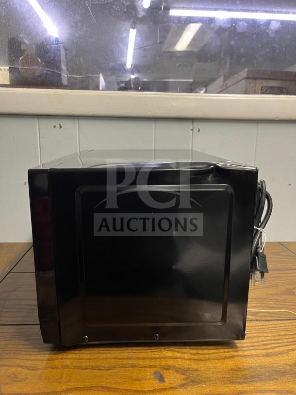 Insignia NS-MW07BKO 0.7 Cu. Ft. compact countertop microwave, black, side view, power cord visible.