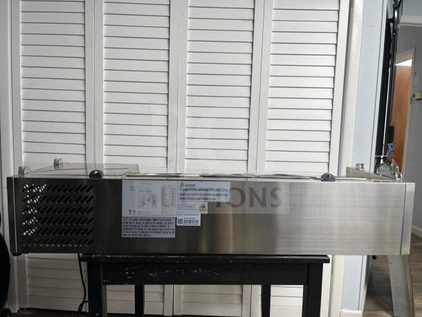 Coldline CTP60SS 60" refrigerated salad bar. Stainless steel, 6 pan capacity. Visible labels with safety warnings.
