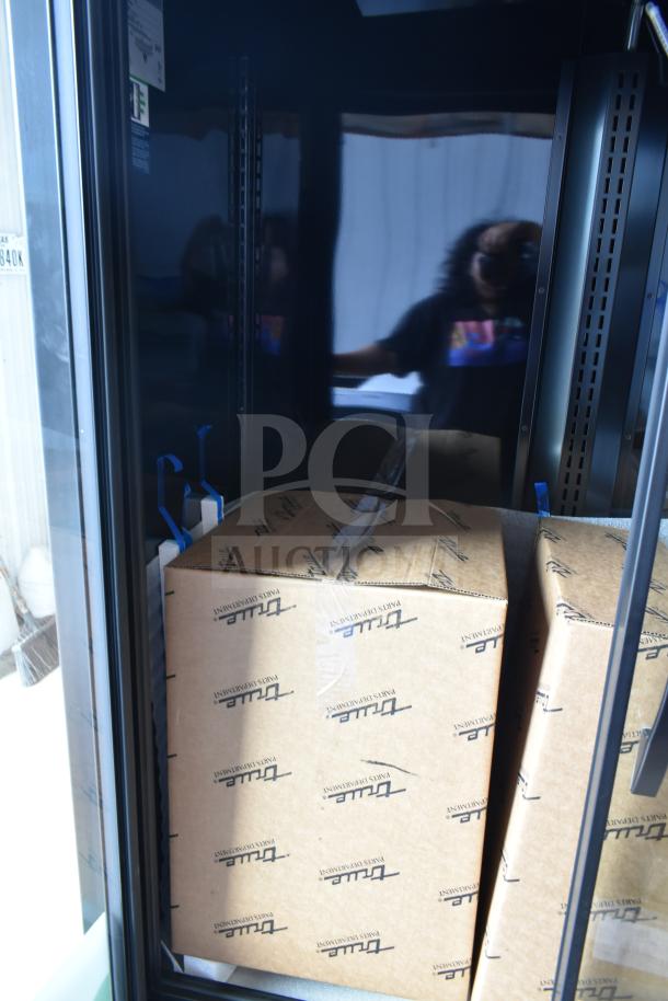 True TVM-48SL-HC black refrigerated glass door merchandiser, new scratch and dent, with LED lighting, 115V.