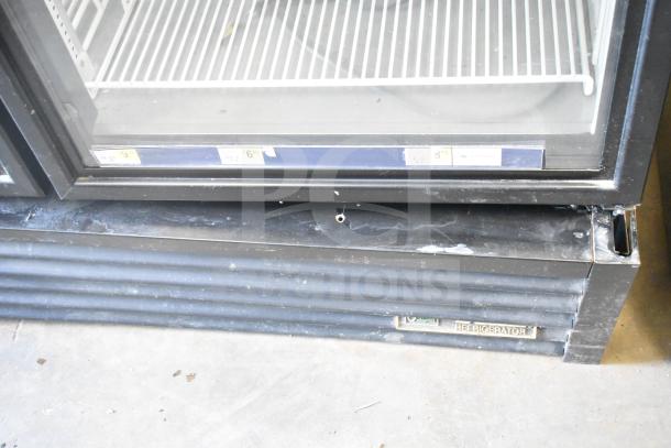 2021 True GDM-49F-HC commercial double-door freezer with glass display, black frame, and visible wear on base panel.