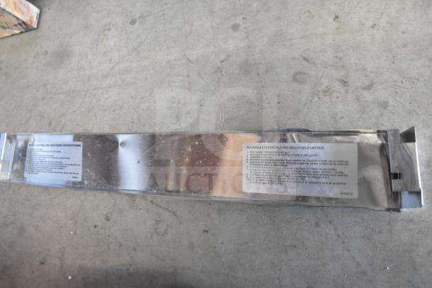 Metal panel with bilingual oven instructions, slight scratches visible on surface.