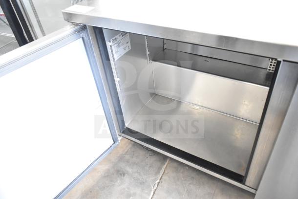 2016 True TWT-60F commercial 2-door worktop freezer with open door, interior view. Commercial casters, 115V, 1 phase.