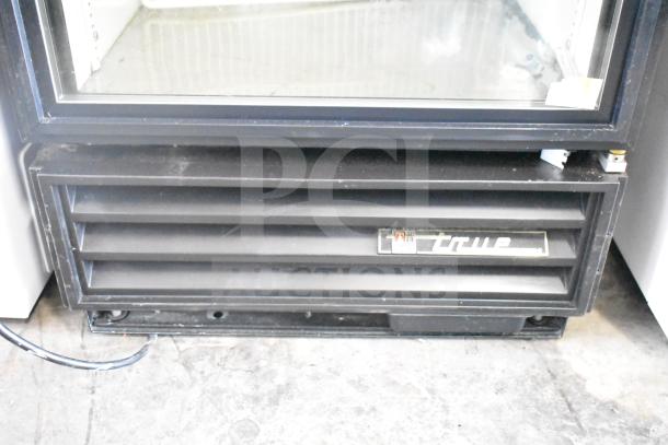 True GDM-12 commercial cooler merchandiser, single door, black finish, 115V, visible True logo, vented front panel.